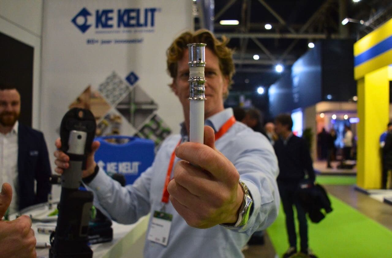 Een klant demonstreert een KE KELIT-fitting op de vakbeurs